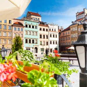 Warsaw old town marketplace square, street lamp in cafe and flowers on foreground